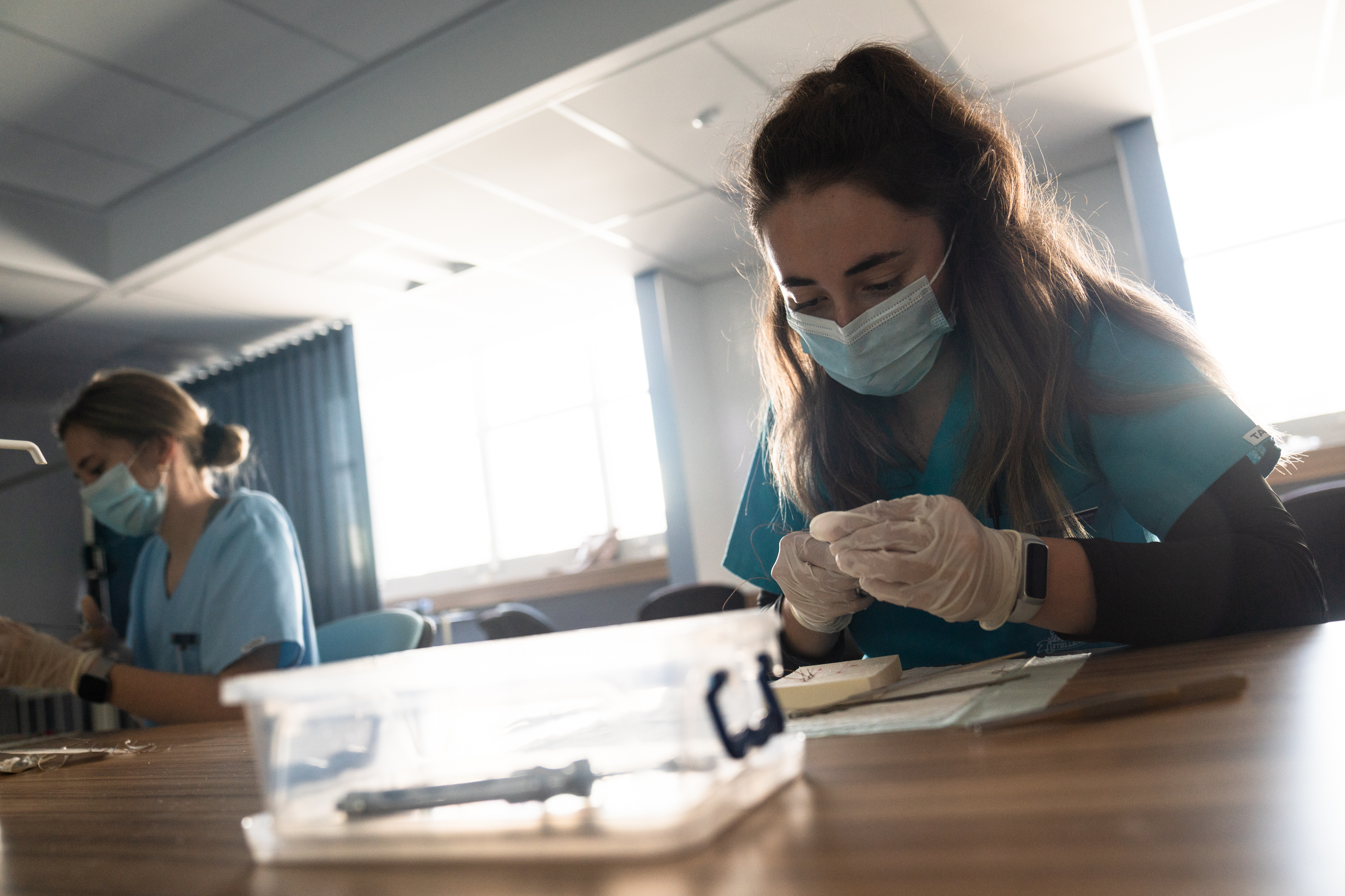 Third-year medical students practice suturing