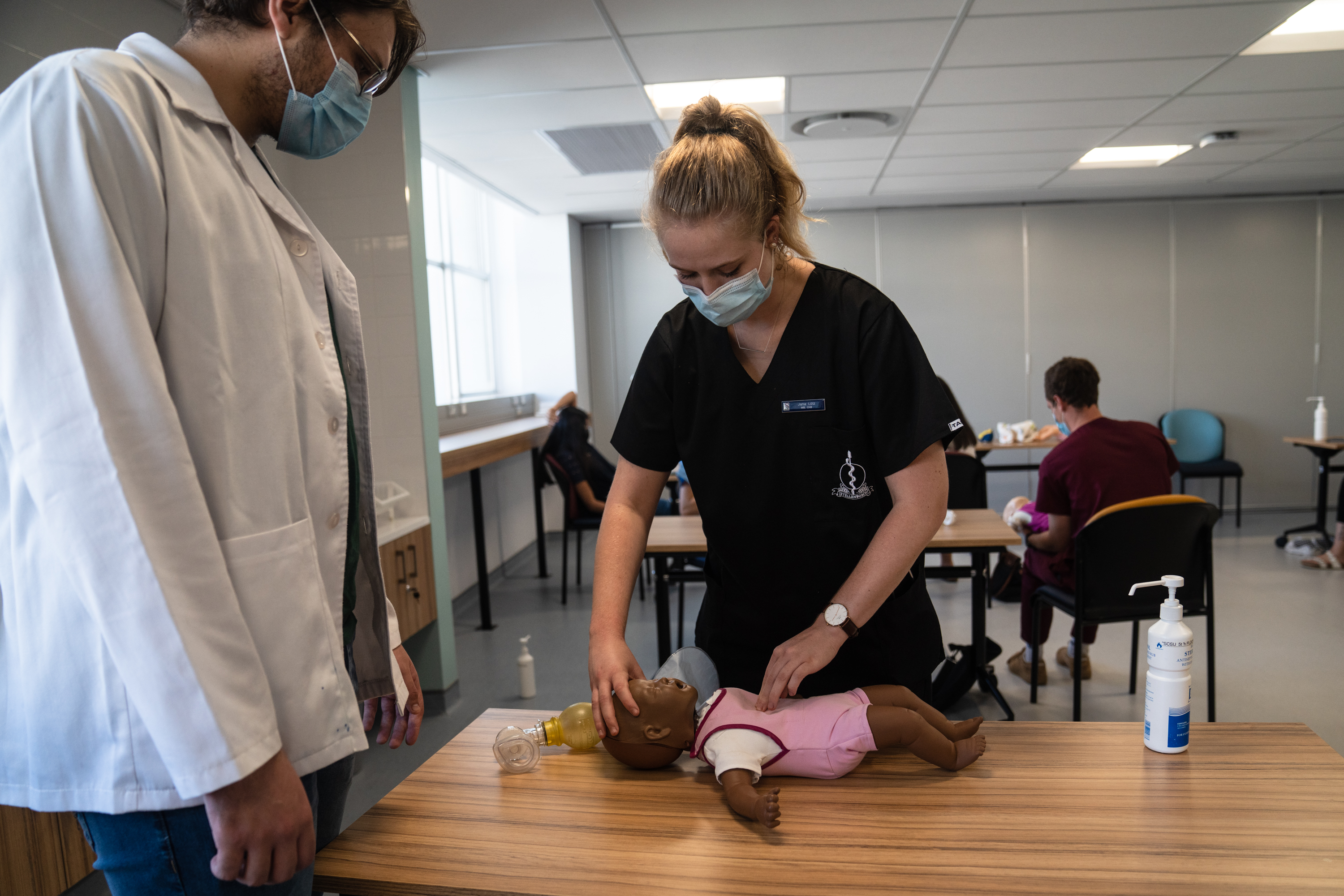 Studente oefen kardiopulminêre resussitasie (KPR) op jong kinders